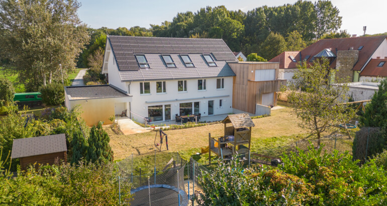 Außenansicht der Wohngemeinschaft mit Garten, Spielturm mit Rutsche und Fußballtoren. 