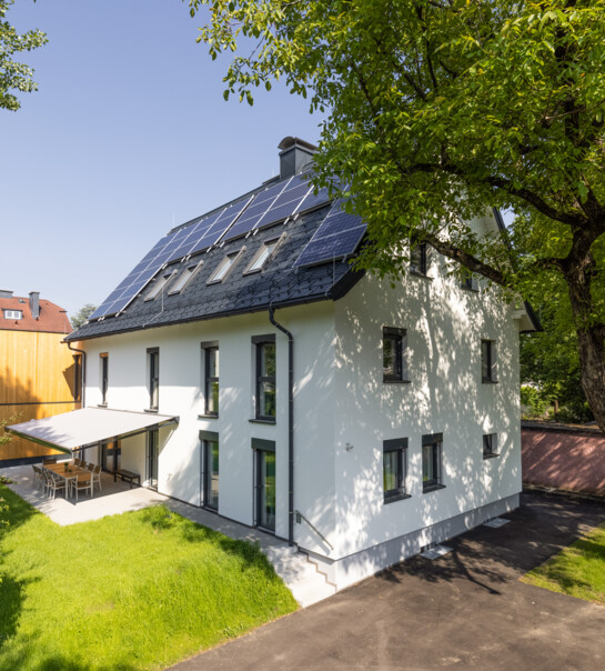 Außenansicht der Wohngemeinschaft mit Garten, und überdachtem Essbereich.