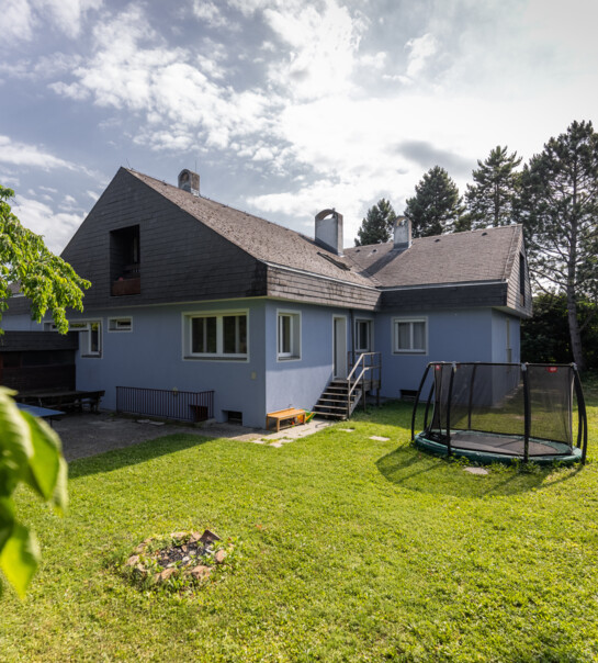 Außenansicht der Wohngemeinschaft mit Garten und Trampolin.